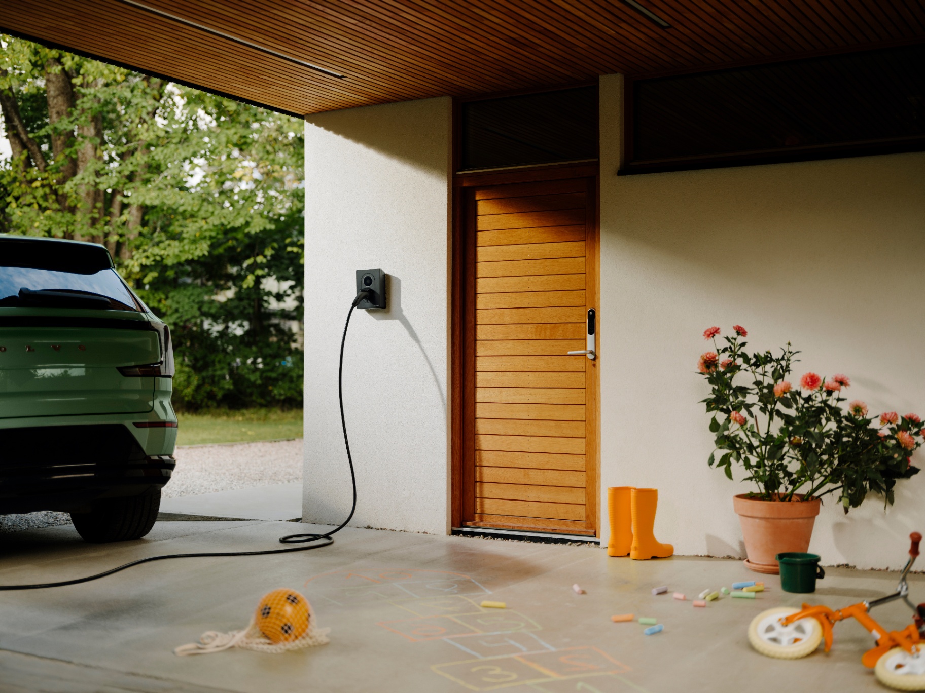 Laddbox installerad på varm fasadvägg med elbil ansluten